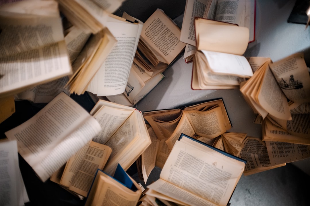 a-pile-of-open-books-sitting-on-top-of-a-table-ihw9k4f18ki